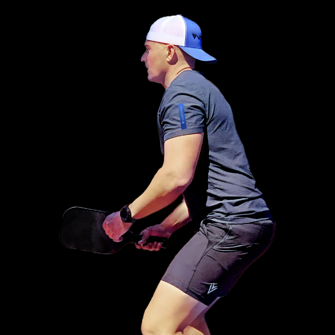 man holding a paddle ready to hit a pickleball